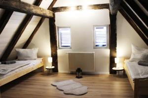 a attic room with two beds and two windows at Workers Apartment in Frickenhausen mit TV & WLAN in Frickenhausen