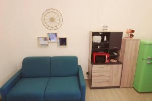 - un salon avec un canapé bleu et un réfrigérateur vert dans l'établissement Casa Cerasella: Beautiful apartment in the city center of Minturno, à Minturno