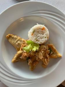 Un plato blanco con algo de comida. en Hotel & Residence La Sibilla Cusiana en Pettenasco
