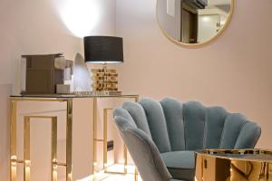 a living room with a blue chair and a mirror at Lumiere Luxury Rooms in Split