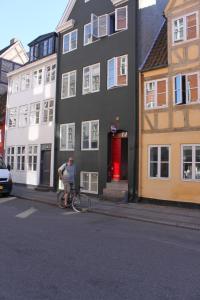 a man riding a bike down a street next to a building at Sankt Annæ 10 in Copenhagen