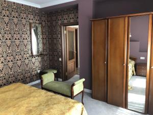 a bedroom with a bed and a chair and a closet at Korona Hotel in Kislovodsk