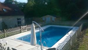 a swimming pool in a yard with a fence at La Grace Les Trois Petites Maisons in Cromac