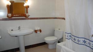 y baño con aseo y lavamanos. en Hotel Antonio Conil, en Conil de la Frontera