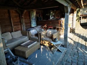 porche con 2 sillas, sofá y mesa en Casa Leone near Bruges with jacuzzi & parking en Ruddervoorde