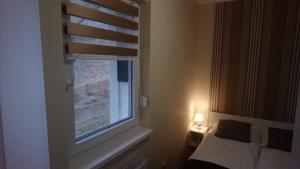 Un dormitorio con una cama y una ventana con un ciego en Apartment Alex, en Lagos de Plitvice