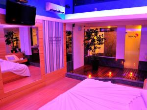 um quarto com luzes roxas e um quarto com uma cama em Motel Sunny (Adult Only) em Belo Horizonte