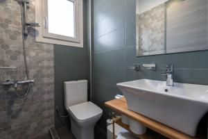 a bathroom with a sink and a toilet at MG Villas & Suites in Paleo Tsifliki +51 photos