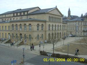 ein großes Gebäude mit Leuten, die davor laufen in der Unterkunft Gästehaus "Rendezvous am Schlossplatz" in Coburg