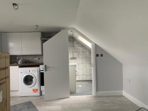 a kitchen with a washer and dryer in a room at Sunny Studio with en-suite in Belvedere