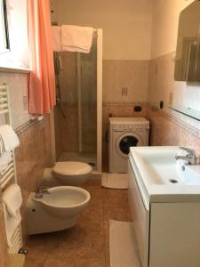 a bathroom with a toilet sink and a washing machine at Casa Guidi in Chiavari