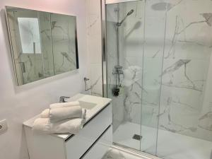 a bathroom with a shower, sink, and mirror at Apartamentos Bruja in Santa Cruz de Tenerife