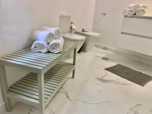 - Baño con aseo y toallas en una mesa en Apartamentos Bruja, en Santa Cruz de Tenerife
