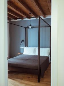 ein Schlafzimmer mit einem Himmelbett und einem Holzboden in der Unterkunft BRE Apartments - Magellano in Vicenza