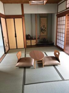 桜井市にあるあまね庵 Villa Amaneの椅子2脚、テーブル、ドアが備わる客室です。