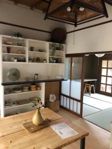 Habitación con mesa de madera y jarrón. en あまね庵 Villa Amane, en Sakurai