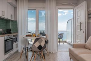 a kitchen and living room with a view of the ocean at MG Villas & Suites in Paleo Tsifliki