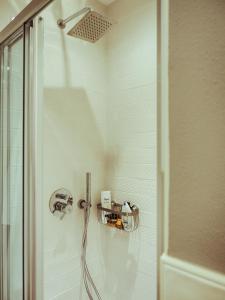 a shower with a hose in a bathroom at BRE Apartments - Magellano in Vicenza