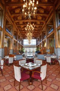 un comedor con mesas y sillas y una lámpara de araña en Pearl Continental Hotel, Muzaffarabad, en Muzaffarabad