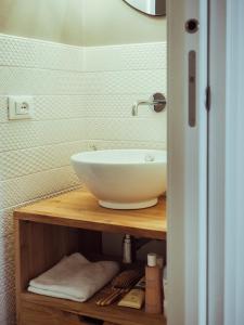 a bathroom with a bowl sink on a wooden shelf at BRE Apartments - Magellano in Vicenza