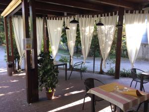 a patio with tables and chairs and white drapes at Aparthotel Manfrè in Vedelago