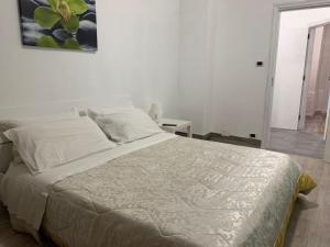 1 dormitorio con 1 cama grande con sábanas blancas en Palazzo Lamanna, en Taranto