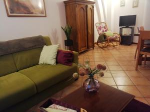 salon z zieloną kanapą i stołem w obiekcie Alle scalette del Duomo w mieście Orvieto