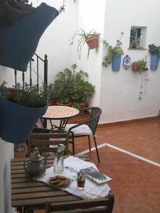 una stanza con tavolo e sedie con piante in vaso di La Lectora a Vejer de la Frontera
