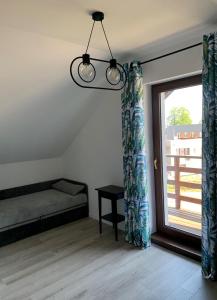 a room with a bed and a window with curtains at Nowe mieszkanie w idealnej okolicy in Pabianice