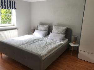 een bed met witte lakens en kussens in een slaapkamer bij Refugium in Ostseenähe in Surendorf