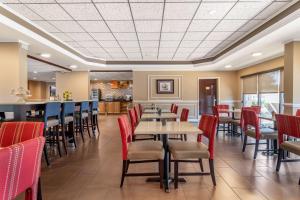 a restaurant with tables and chairs and a bar at Comfort Inn & Suites in Athens