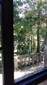 una finestra con vista su una recinzione e sugli alberi di A Bouza a Samieira