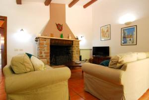 een woonkamer met 2 banken en een open haard bij Monte Malbe Charming Villa with Garden and Parking in Perugia