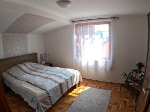 a bedroom with a bed and a window at Katica Nyaraló in Tiszakécske