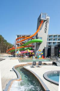 a water park with a water slide in front of a building at Hotel Zalewski in Mrzeżyno