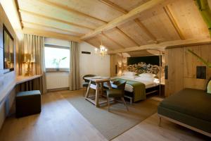 a bedroom with a bed and a table and chairs at Geniesserhotel Minglers Sportalm 4 Sterne Superior in Kirchberg in Tirol