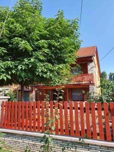una valla de madera frente a una casa en Katica Nyaraló, en Tiszakécske