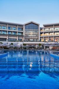 a large swimming pool in front of a building at Atlantica Mare Village Paphos in Paphos City