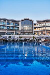 Atlantica Mare Village Paphos في بافوس: مسبح كبير امام مبنى