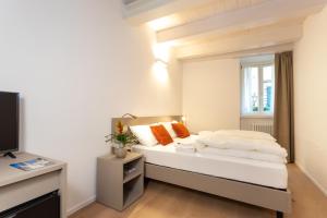 Schlafzimmer mit einem Bett und einem Fenster in der Unterkunft Locanda Le Due Travi in Trient