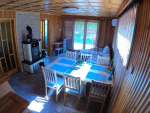 a living room with a table and chairs and a stove at Katica Nyaraló in Tiszakécske +17 photos