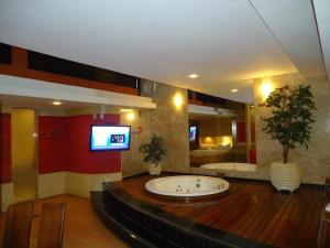 um quarto grande com uma grande banheira no meio em Motel Sunny (Adult Only) em Belo Horizonte