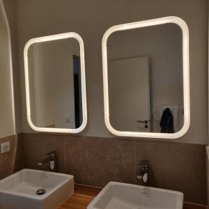 two mirrors above a white sink in a bathroom at Mas Partout in Malaucène