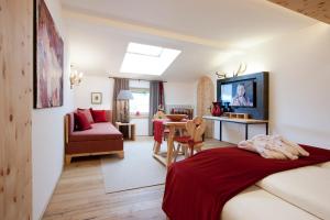 1 dormitorio con 1 cama y sala de estar en Minglers Sportalm - Das Gourmet- und Genießerhotel, en Kirchberg in Tirol