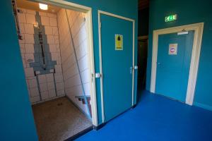 a bathroom with blue walls and a blue door at Strowis Hostel in Utrecht