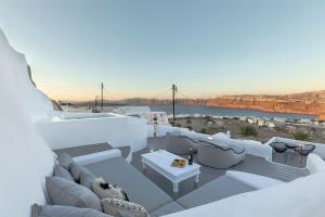 un patio en la azotea con sofás y vistas a Theania en I-Sol en Akrotiri