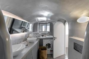 a bathroom with two sinks and a washing machine at I-Sol in Akrotiri