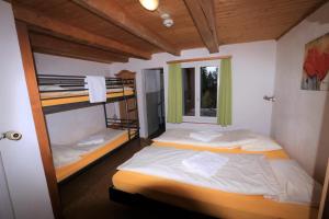 a bedroom with two bunk beds and a window at juhui Flumserberg in Flumserberg