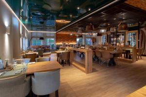 a restaurant with wooden tables and chairs and a bar at Hotel-Restaurant Termunterzijl in Termunterzijl