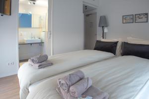 Una cama blanca con toallas encima. en Hotel-Restaurant Termunterzijl, en Termunterzijl